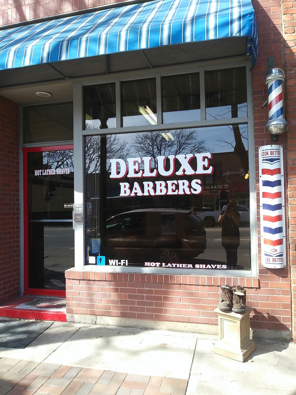 The earlier Deluxe Barbers storefront at 459 Main Street with its blue awning and gold window lettering