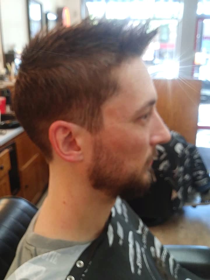 Side profile of a finished fade haircut with a full beard