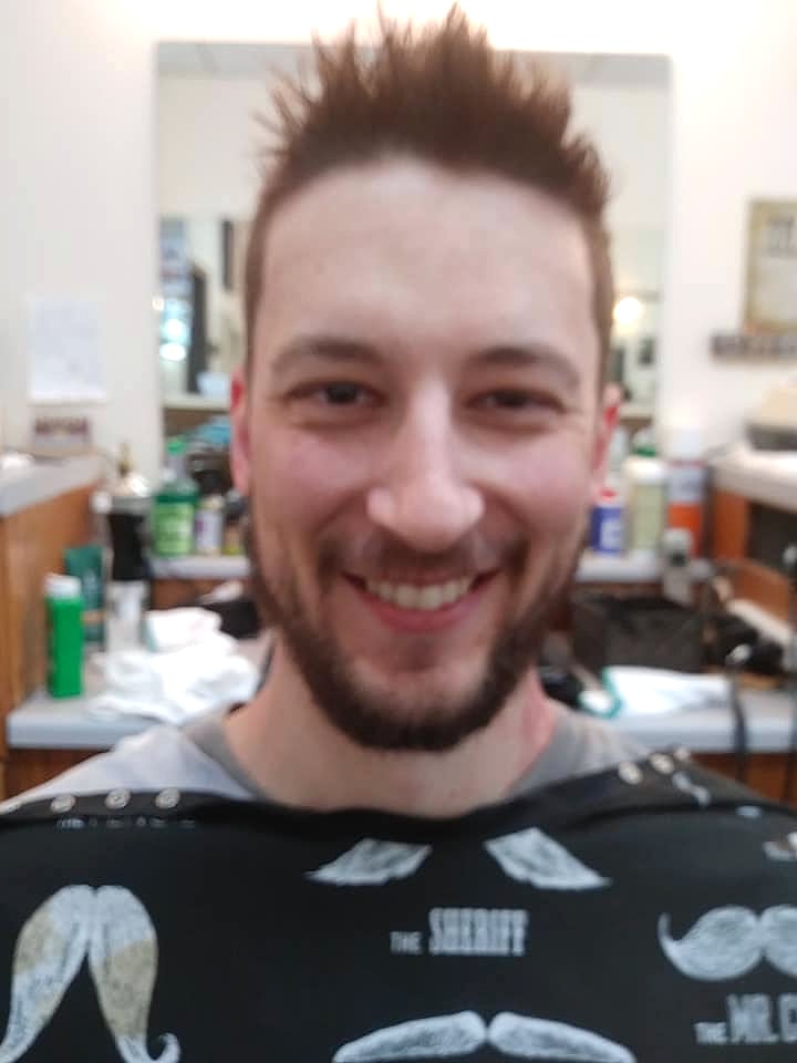 Smiling client with a fresh haircut and full beard